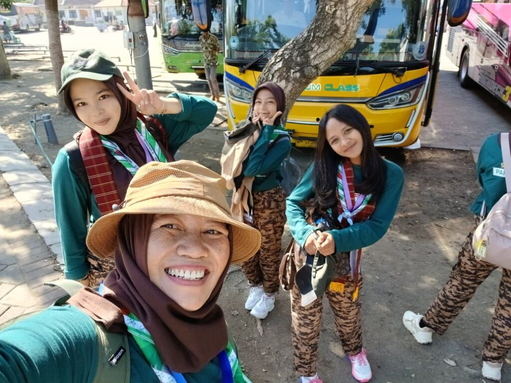 Sejumlah peserta remaja kemah Scouting for Peace and Humanity berpose santai di area parkir bus